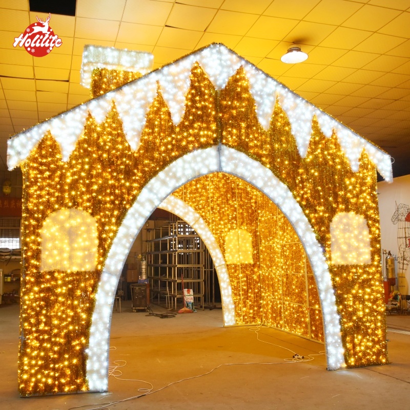 Large-scale gingerbread house-shaped holiday lighting display with a galvanized frame, waterproof LED lights, and fire-resistant tinsel