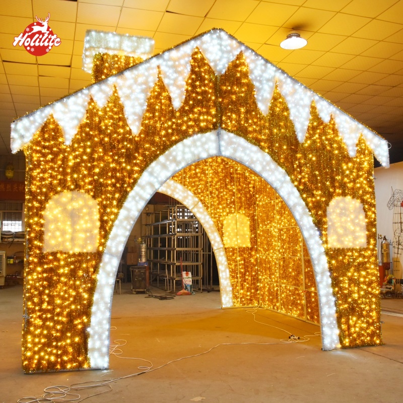 Large-scale gingerbread house-shaped holiday lighting display with a galvanized frame, waterproof LED lights, and fire-resistant tinsel
