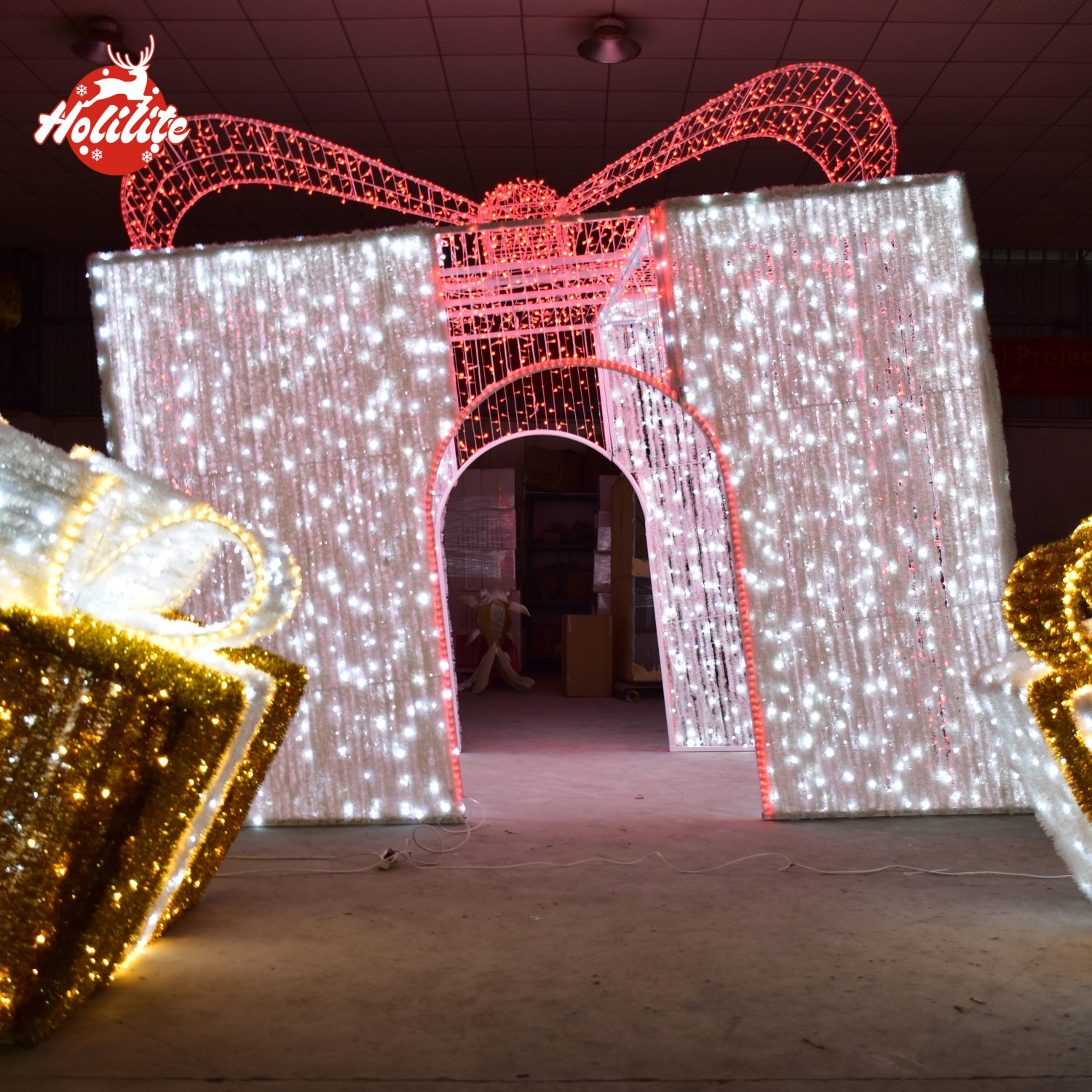 This image highlights a large Christmas arch light shaped like a gift box, using waterproof LED light strings and a reinforced steel frame. The design is suitable for long-term outdoor installations in theme parks, scenic areas, and holiday event venues.