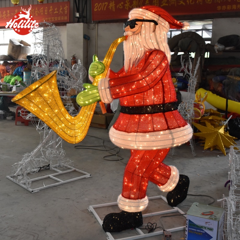 Illuminated Santa Claus trumpet Christmas light sculpture at night