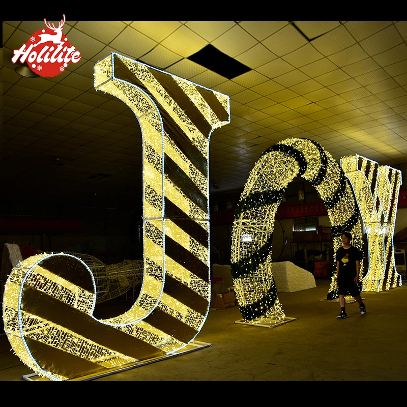 Gran escultura luminosa de letras iluminada al aire libre, instalada como escaparate comercial nocturno