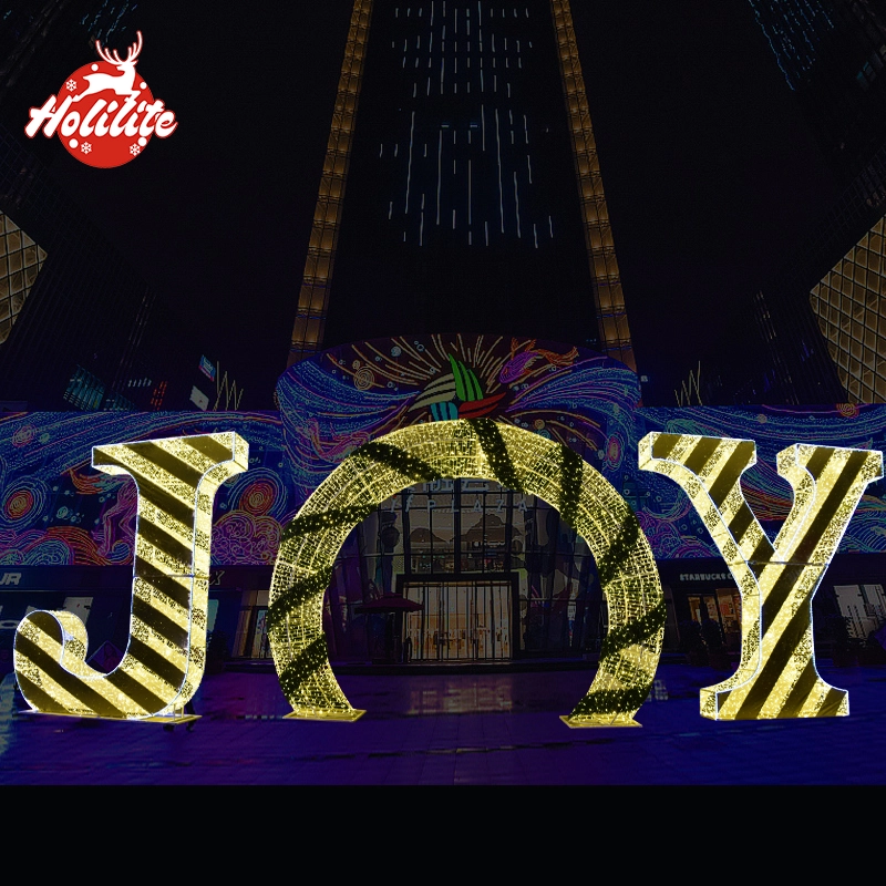 Decoración luminosa de letras en el exterior utilizada en una plaza comercial para crear un ambiente festivo